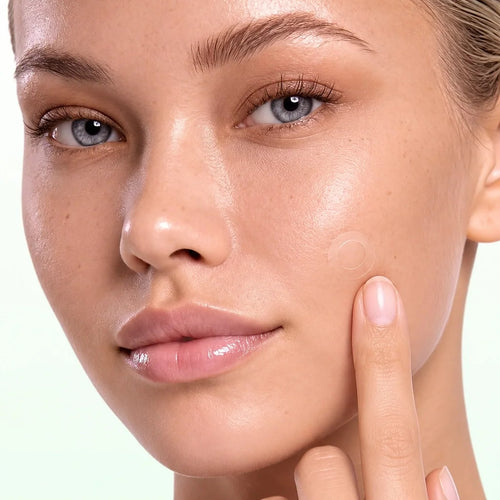 A clear spot patch on a woman's cheek, almost invisible on bare skin